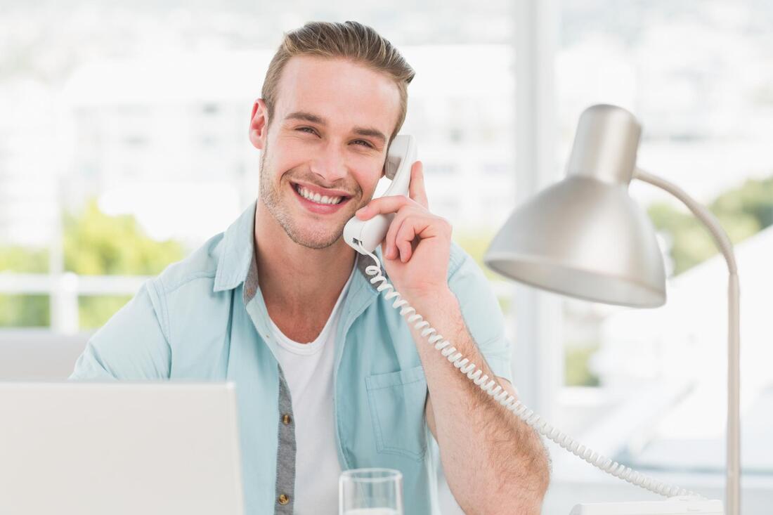 man happily taking telephone call